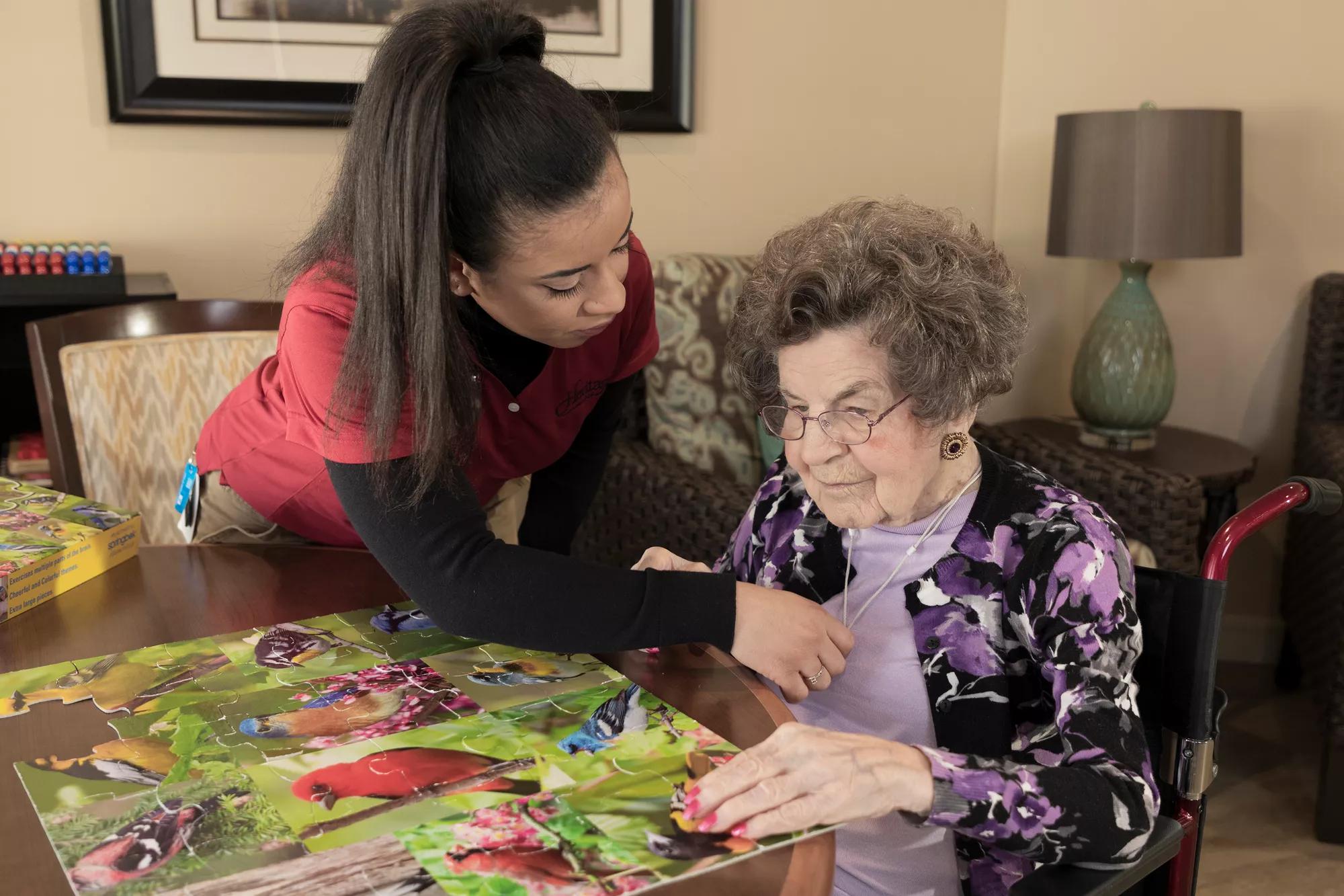 Senior Living community caregiver visits with resident, who uses an Arial e-call pendant by Securitas Healthcare