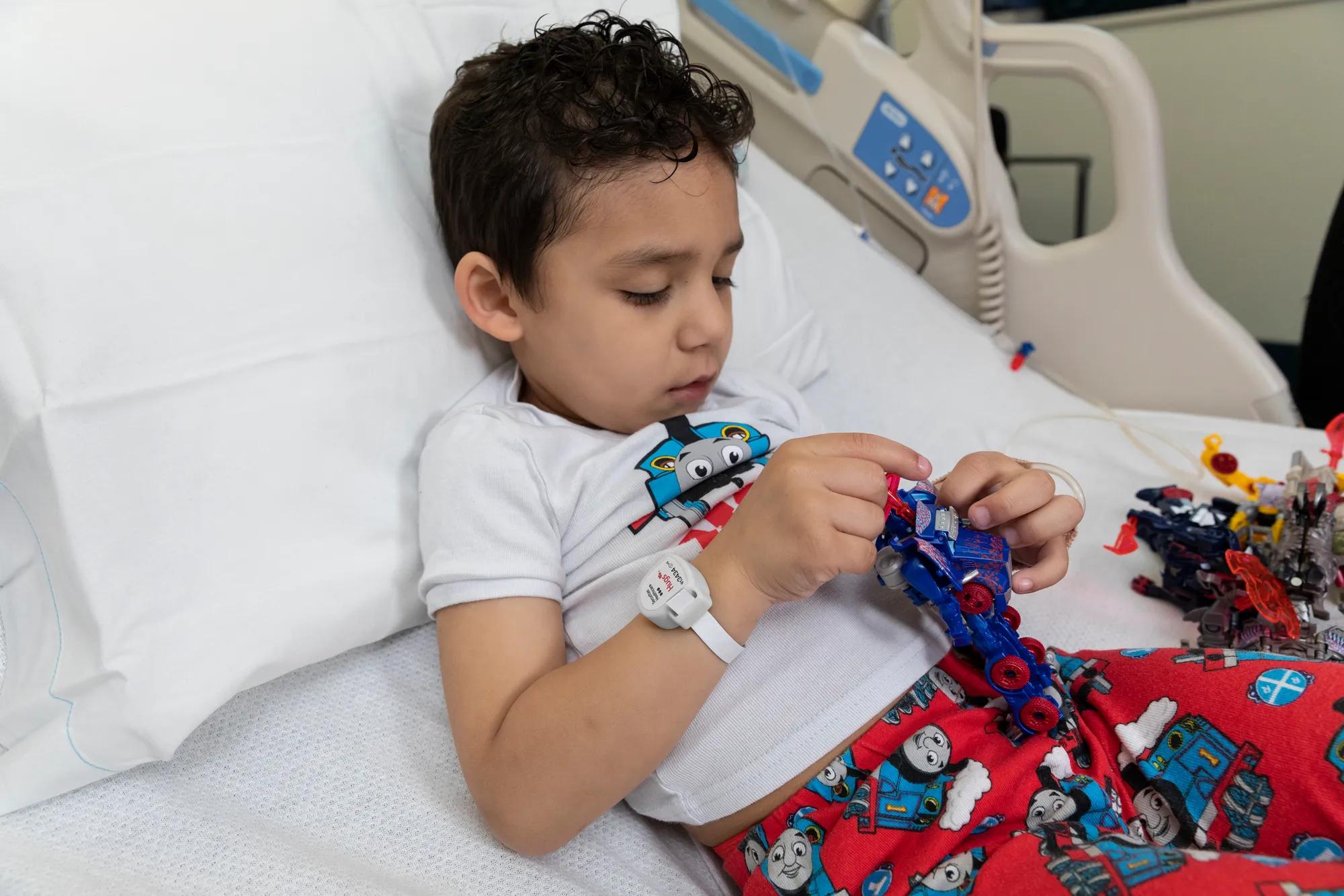 Pediatric patient boy laying in hospital bed wearing the Hugs Infant Protection solution band around his wrist. Securitas Healthcare.