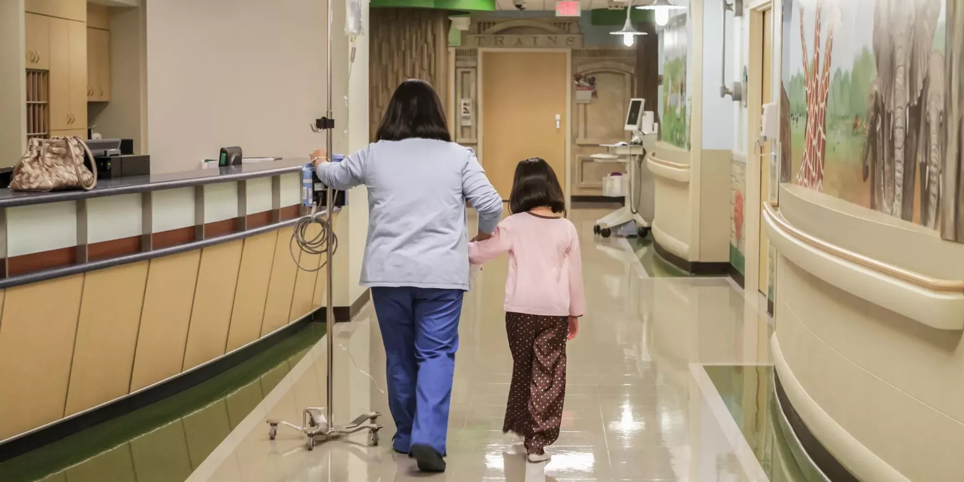 Nurse and girl walking in Hospital hallway, patient protection Securitas Healthcare.