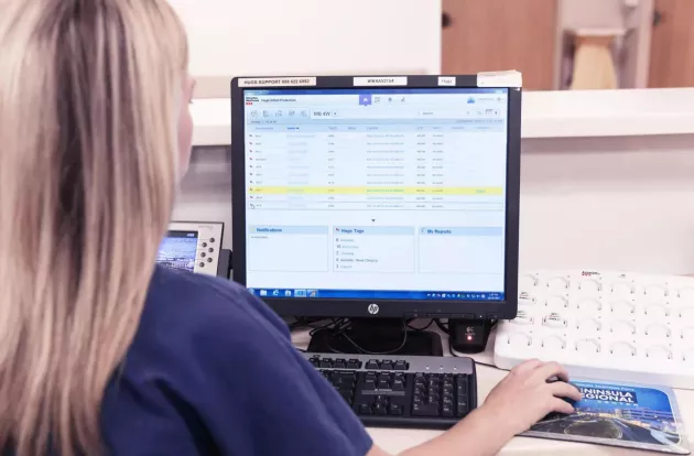 Caregiver operating the Hugs Infant Protection solution on a computer