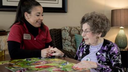 Senior Living community caregiver visits with resident, who uses an Arial e-call pendant by Securitas Healthcare